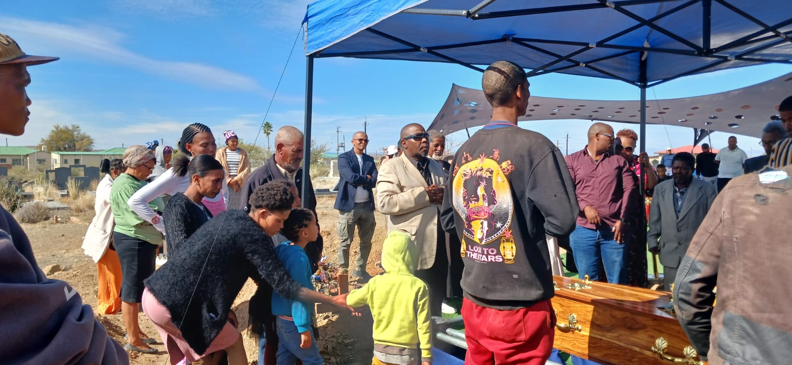 Family and community paying their respects at the graveside